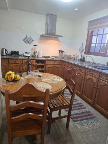 a kitchen with a wooden table with chairs and a sink at Charming Retreat Machico - 5 min Praia & Centro B in Machico