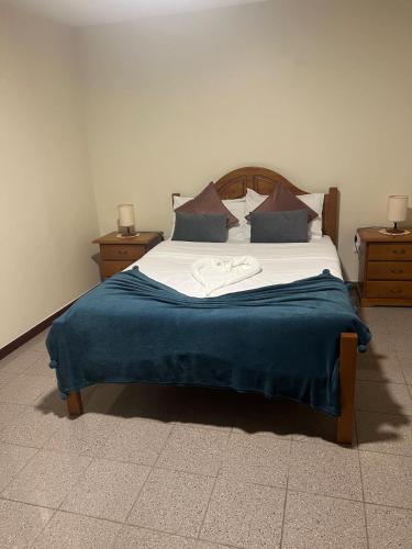 a bedroom with a large bed with a blue blanket at Charming Retreat Machico - 5 min Praia & Centro B in Machico