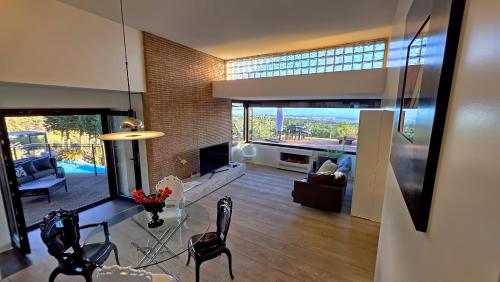 a living room with a table and chairs and a large window at Rahal Luxury Between Etna & Sea - Heated Jacuzzi & Infinity Pool in Catania