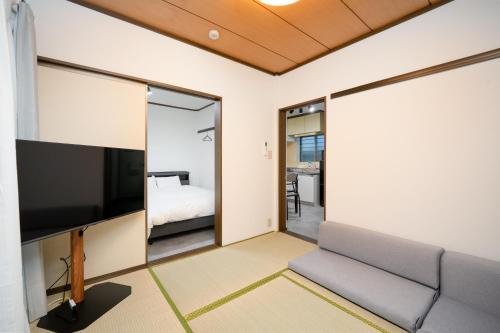 a living room with a couch and a tv at Vacation Inn Haneda 1 in Tokyo
