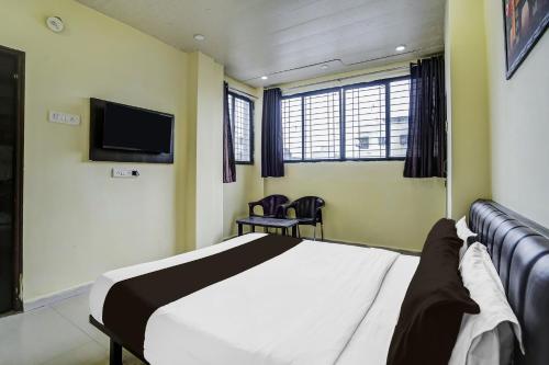 a bedroom with a bed and a flat screen tv at HOTEL O REGAL INN in Dhantoli