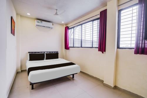 a bedroom with two beds in a room with windows at HOTEL O REGAL INN in Dhantoli