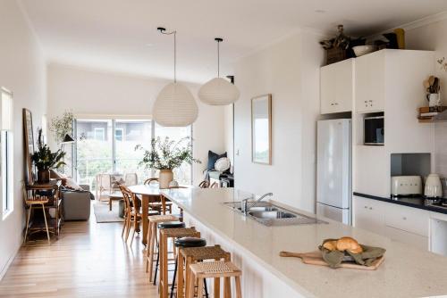 a kitchen with a counter with chairs and a counter top at Seafarers Lodge a pup friendly beach shack haven in Middleton in Middleton