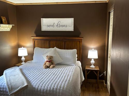 a teddy bear sitting on a bed in a bedroom at Little Main Street Inn in Banner Elk