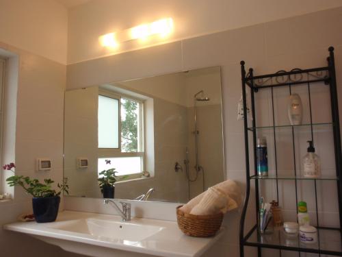 a bathroom with a sink and a large mirror at Lovely home above the Kinneret in Karkom