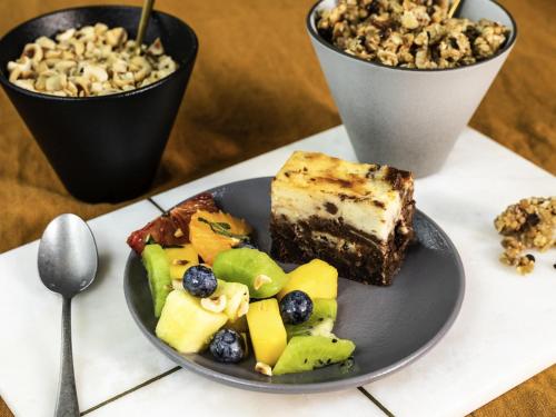 un plato de comida con un trozo de tarta y fruta en Mercure Kuala Lumpur Shaw Parade, en Kuala Lumpur