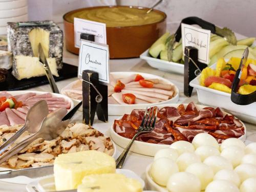 uma mesa com muitos tipos diferentes de comida em Mercure Paris Saint-Ouen em Saint-Ouen