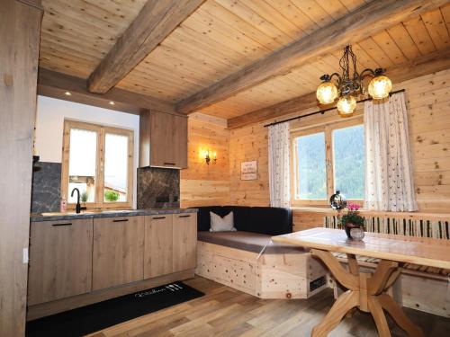 a kitchen with a couch and a table in a room at Rustic cabin with sauna near the ski area in Pankrazberg