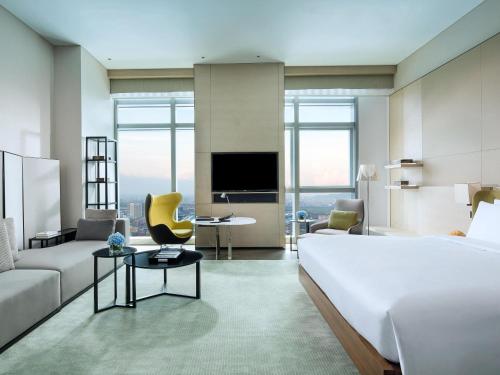 a hotel room with a large bed and a living room at Sofitel Foshan Shunde in Shunde