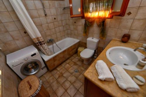 a bathroom with a sink and a toilet and a tub at Villa Pergola in Pyrgi