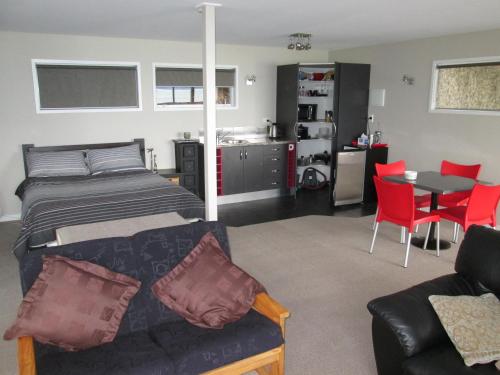 um quarto com uma cama, um sofá e uma mesa em Beach side Apartment Nelson em Nelson