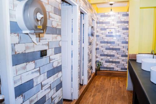a bathroom with two sinks and a brick wall at Bed & Beach Hostel Karon in Ban Karon