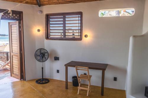 a room with a table and a fan and a window at Il Gatto Rosso in San Agustinillo