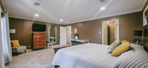a bedroom with a bed and a desk and a television at Calmer Daze in Hot Springs