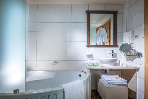 a bathroom with a tub and a sink at Koutrakis Suites by Estia in Sissi