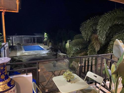 a balcony with a swimming pool at night at Mom Shie's Apartelle in Las-ud