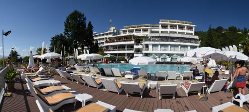 a resort with a pool and chairs and a building at Hotel Granit in Ohrid
