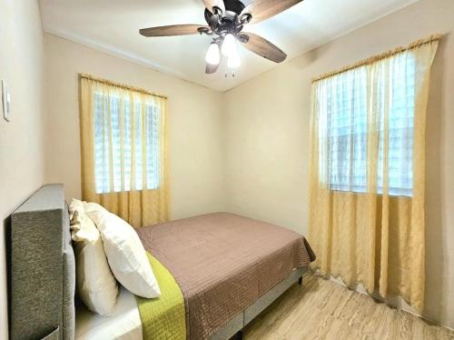 a bedroom with a bed and a ceiling fan at 3Bd House 8 min to Int'l Airport with WiFi, Gated Parking and Hot Wtr in Ladyville