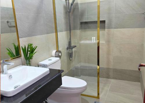 une salle de bain avec un lavabo, des toilettes et une douche dans l'établissement KKP Hotel, à Kampot