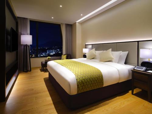 a hotel room with a large bed and a window at Grand Mercure Ambassador Hotel and Residences Seoul Yongsan in Seoul