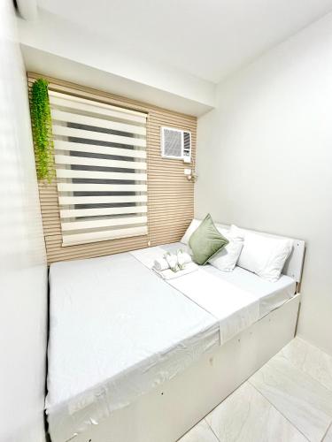 a bedroom with a large bed with a window at 2 Bedroom Condo Fully-Furnished good for 5-6pax by Gerra at Urban Deca Homes Banilad in Mandaue City