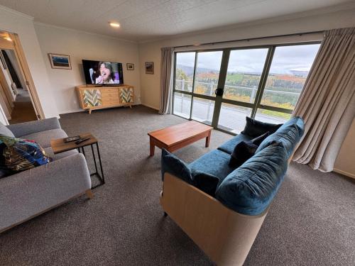 a living room with a couch and a large window at Entire home in Roxburgh in Roxburgh