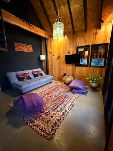 a bedroom with a bed and pillows on a rug at Mi Refugio Nordico Buho Cabin in San Miguel