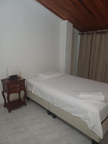 1 dormitorio con cama y mesa con ordenador portátil en El Palmar, en Palmira