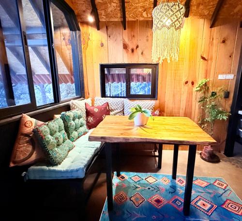 a room with a wooden table and a couch at Mi Refugio Nordico Buho Cabin in San Miguel