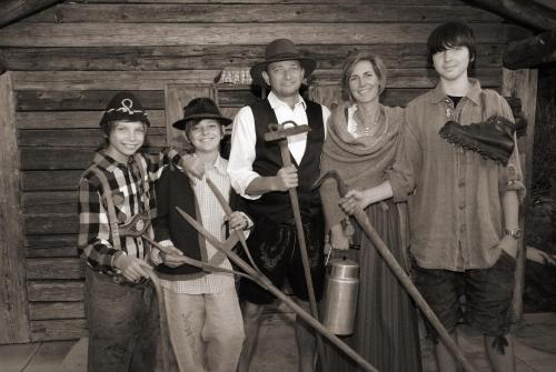 a black and white photo of a family posing in front of a cabin at Zugspitzhotel Diana Thörle in Ehrwald