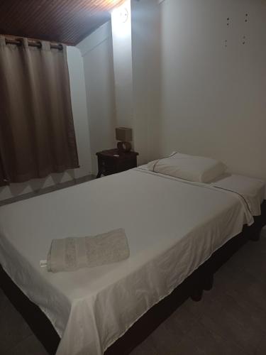 una camera da letto con un letto bianco con un asciugamano sopra di El Palmar a Palmira