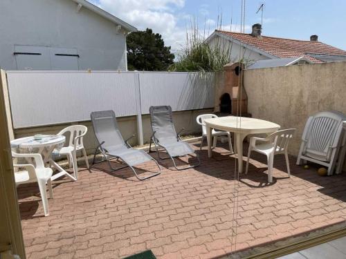 a patio with chairs and tables and a fence at Maisonette plain-pied avec cour fermée, proche plage et commerces - FR-1-476-248 in La Faute-sur-Mer