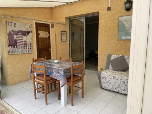 a room with a table and chairs and a couch at Maisonette plain-pied avec cour fermée, proche plage et commerces - FR-1-476-248 in La Faute-sur-Mer