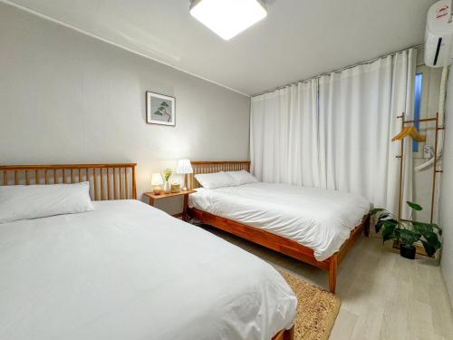 a bedroom with two beds and a window at Oknuri in Seoul