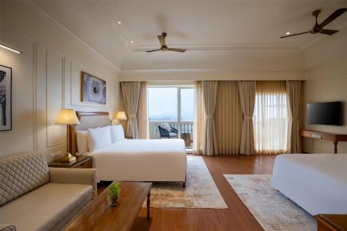 a hotel room with a bed and a couch at Radisson Resort Mount Abu in Mount Ābu