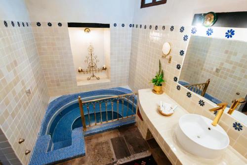 a bathroom with a sink and a bath tub at Hacienda El Carmen Hotel & Spa in Portes Gil