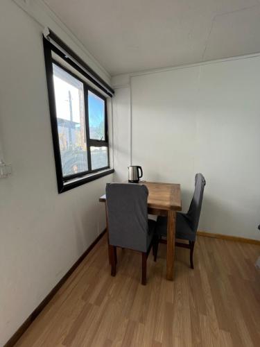 a dining room with a table and two chairs at Habitación independiente con baño privado in Cochrane