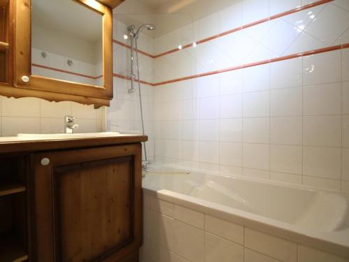 a bathroom with a tub and a sink and a mirror at Appartement 4 pièces 8 pers rénové avec parking aux Carroz d'Arâches - FR-1-572-335 in Arâches-la-Frasse