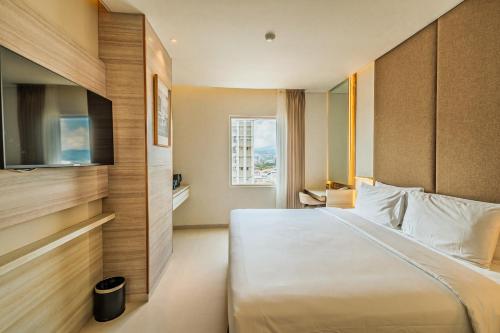 une chambre d'hôtel avec un lit et une fenêtre dans l'établissement Gino Feruci Braga by KAGUM Hotels, à Bandung