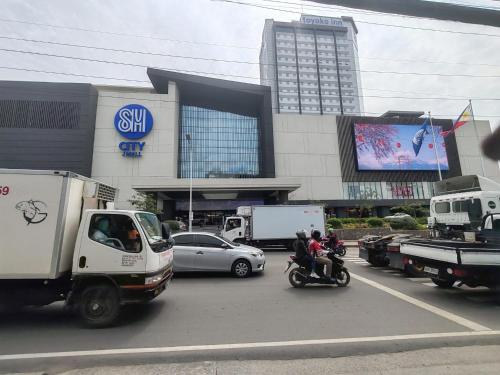 a group of cars and trucks parked in front of a building at J Tower Residences in Bakilid