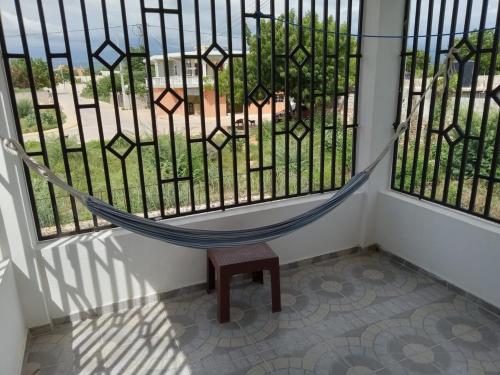 a hammock in front of a window with a view at 2-bedroom condo close to the beach and mountain in Pedernales