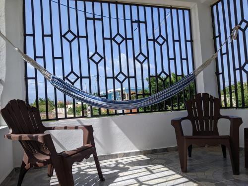 two chairs and a hammock in front of a window at 2-bedroom condo close to the beach and mountain in Pedernales