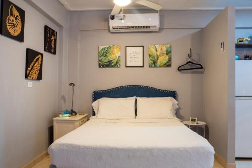 a bedroom with a bed and some pictures on the wall at Compound sleeps 20, bedrooms with AC, Gated Parking and hot baths in Ladyville