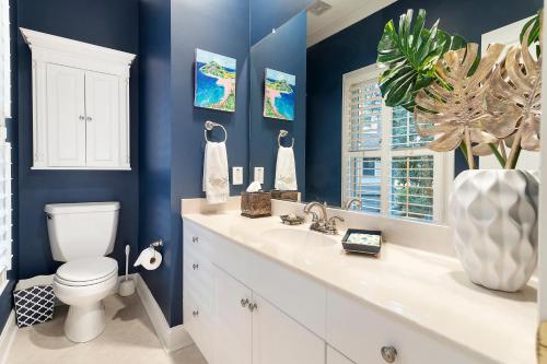 a blue bathroom with a toilet and a sink at OG23: 23 Ocean Green in Kiawah Island