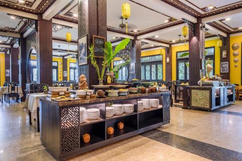 um restaurante com uma linha de buffet com pratos em Koi Resort & Spa Hoi An em Hoi An