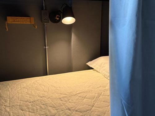 a bedroom with a bed with a light on it at Hosanna Hostel in Chiang Mai