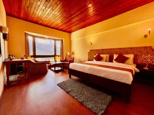 a bedroom with a large bed and a living room at Sagar Resort Manali By Ramanand Sagar Ramayan Maker-#Near Mall Road # Big Parking # Mountain View in Manāli