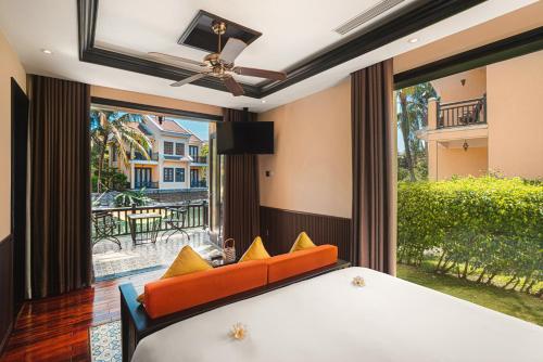 a bedroom with a bed and a large window at Koi Resort & Spa Hoi An in Hoi An