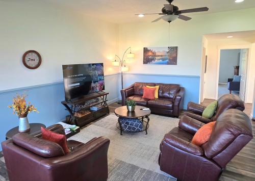 a living room with leather furniture and a flat screen tv at Immaculate Home w/ Mtn and River Views! in East Wenatchee