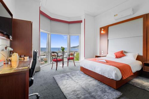 a bedroom with a bed and a table and chairs at Oakleigh House in Burnie